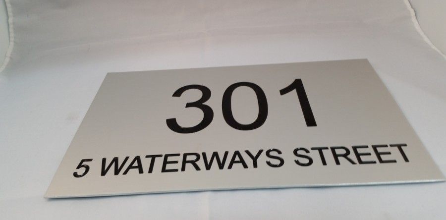 A Silver Sign With the Number 301 on It is Sitting on a White Surface — Total Engraving In Sandgate, NSW