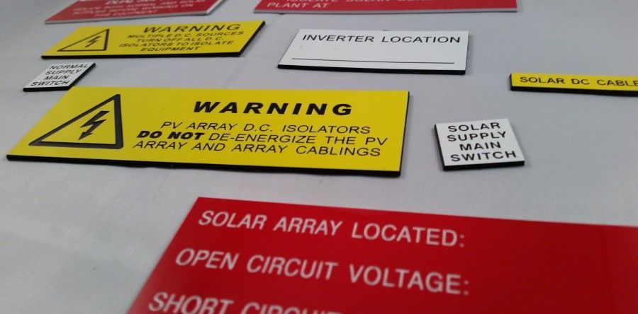 A Bunch of Warning Signs Including One That Says Solar Array Located — Total Engraving In Sandgate, NSW