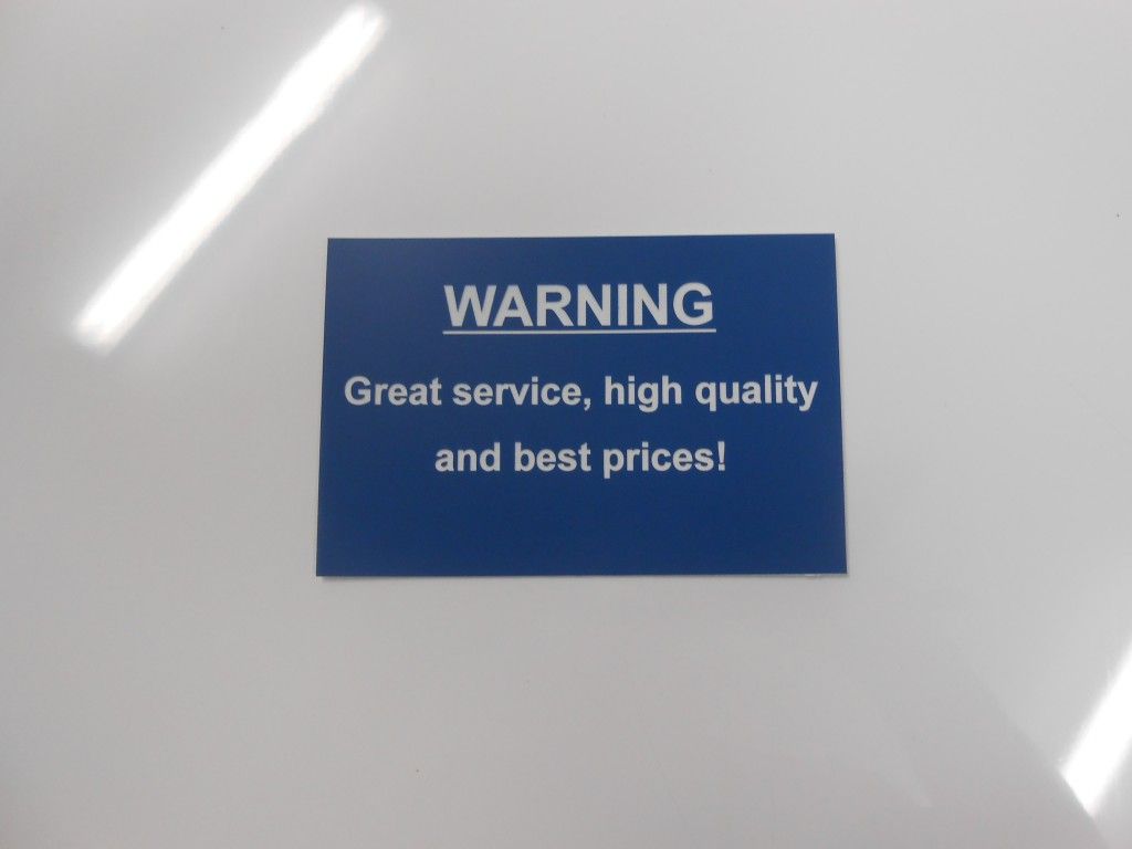 A Blue Sign That Says Warning Great Service High Quality and Best Prices — Total Engraving In Sandgate, NSW