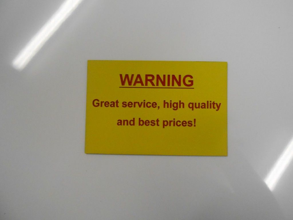 A Yellow Sign That Says Warning Great Service High Quality and Best Prices — Total Engraving In Sandgate, NSW