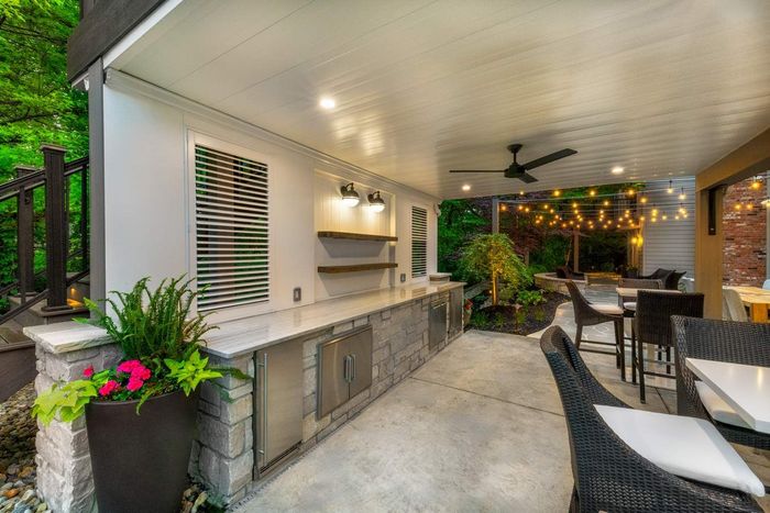 There is a large outdoor kitchen with a ceiling fan.