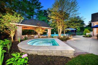 A backyard with a swimming pool and a gazebo