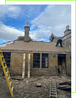 Construction workers repairing a stone building's roof under a cloudy sky.