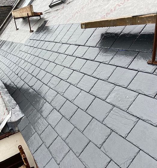 Newly installed gray slate roof with wooden scaffolding.