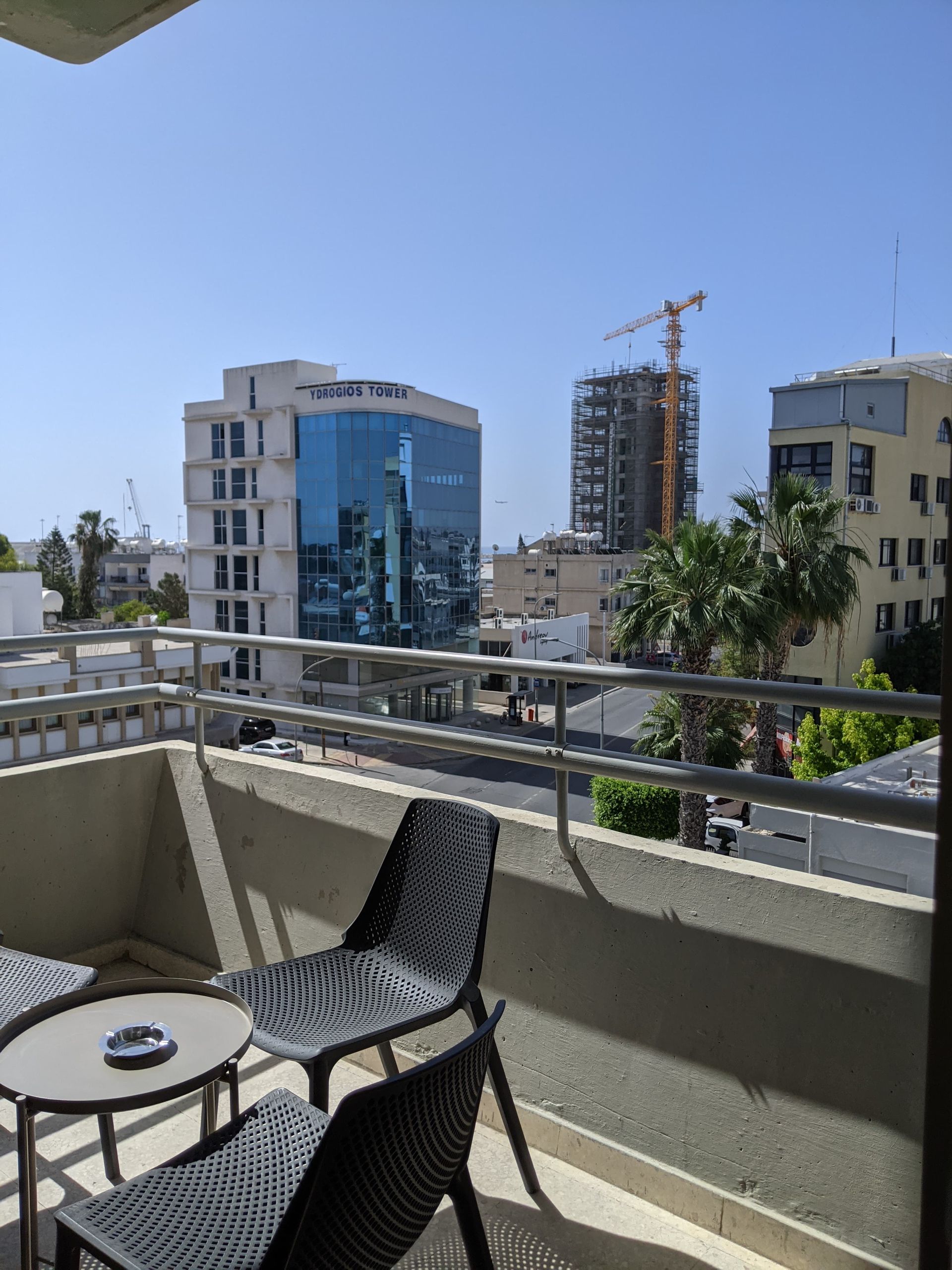 Two chairs and a table on a balcony overlooking a city