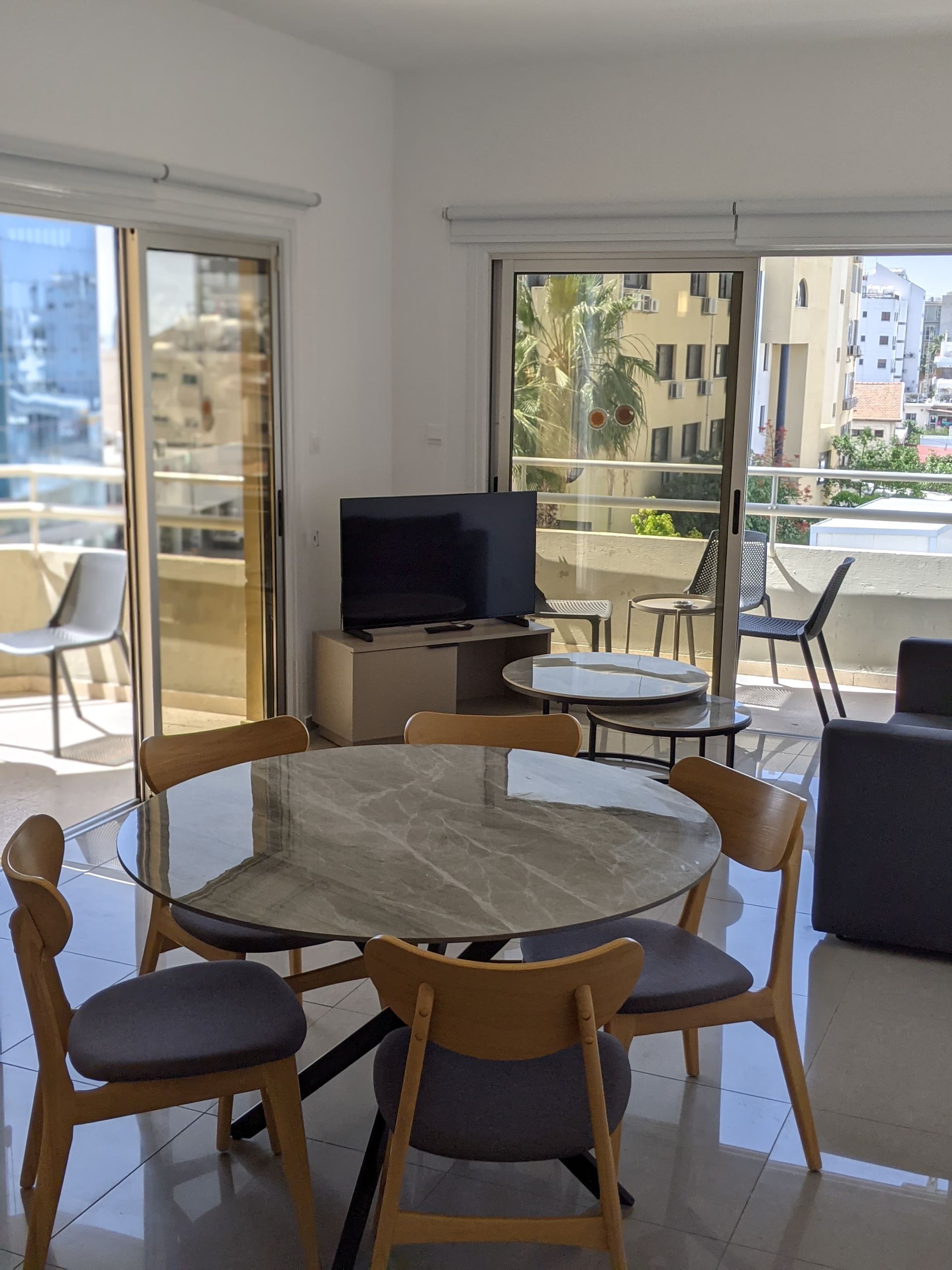 A living room with a round table and chairs and a flat screen tv