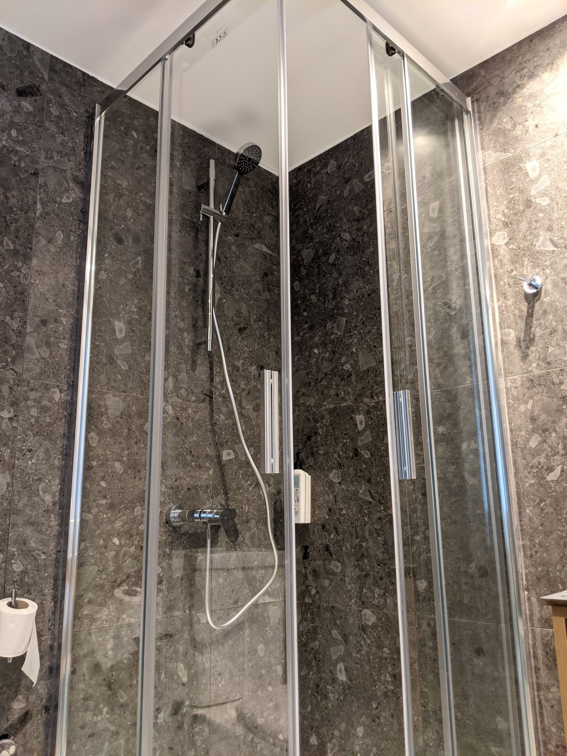 A bathroom with a shower stall and a shower head.