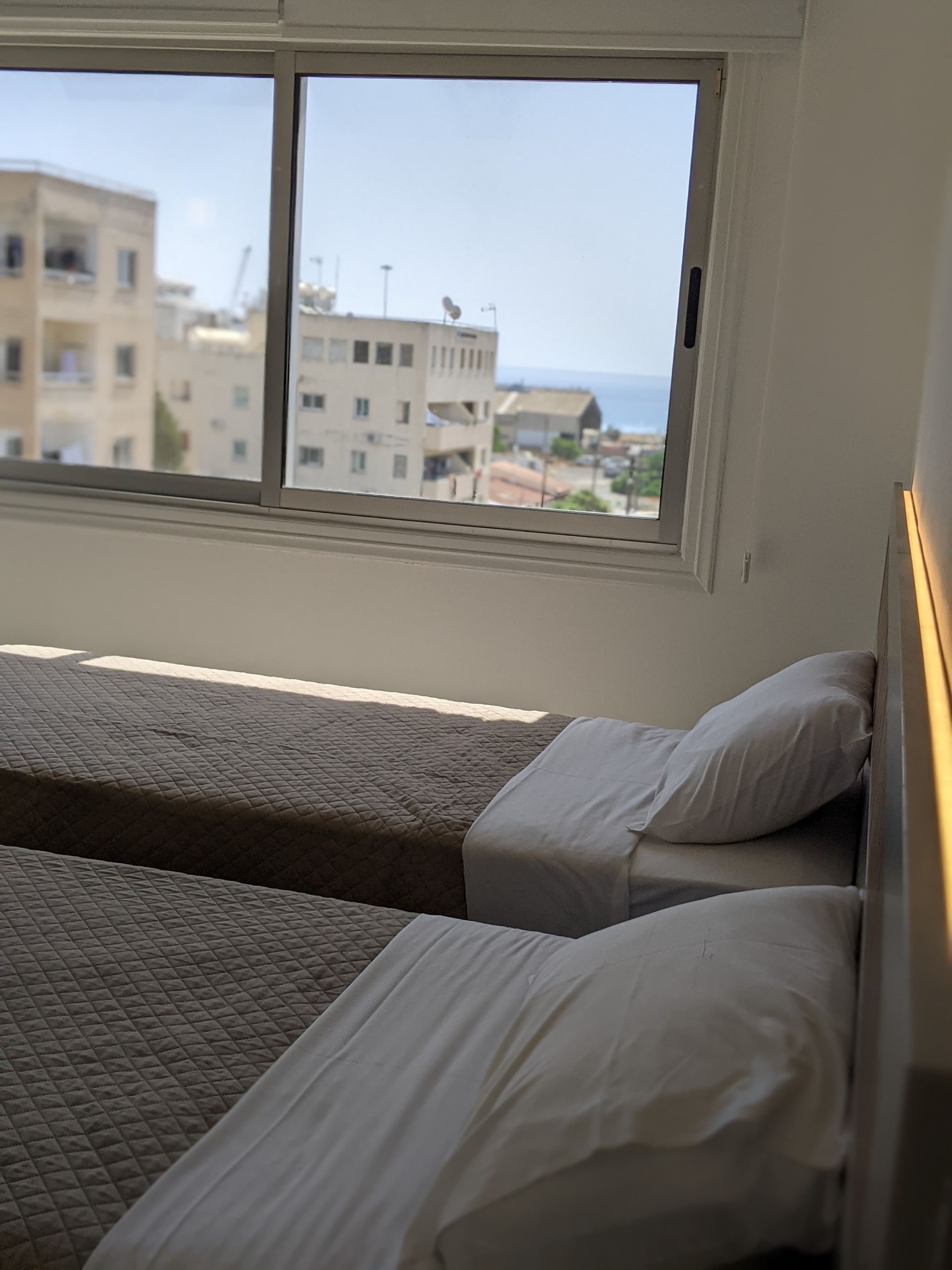 A hotel room with two beds and a large window
