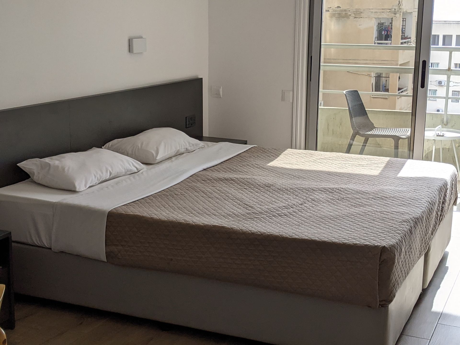 A hotel room with a large bed and a sliding glass door