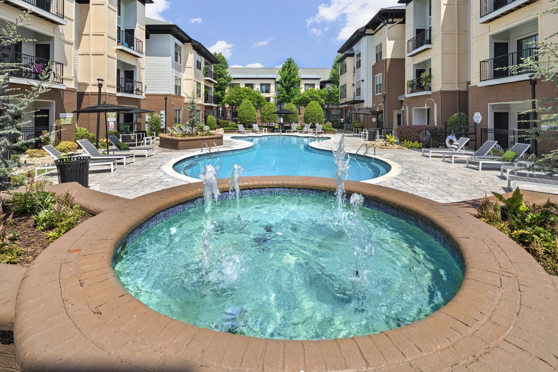 A large swimming pool with a fountain in the middle of it