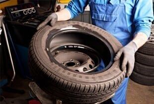 Mechanical repairs a tire in the garage