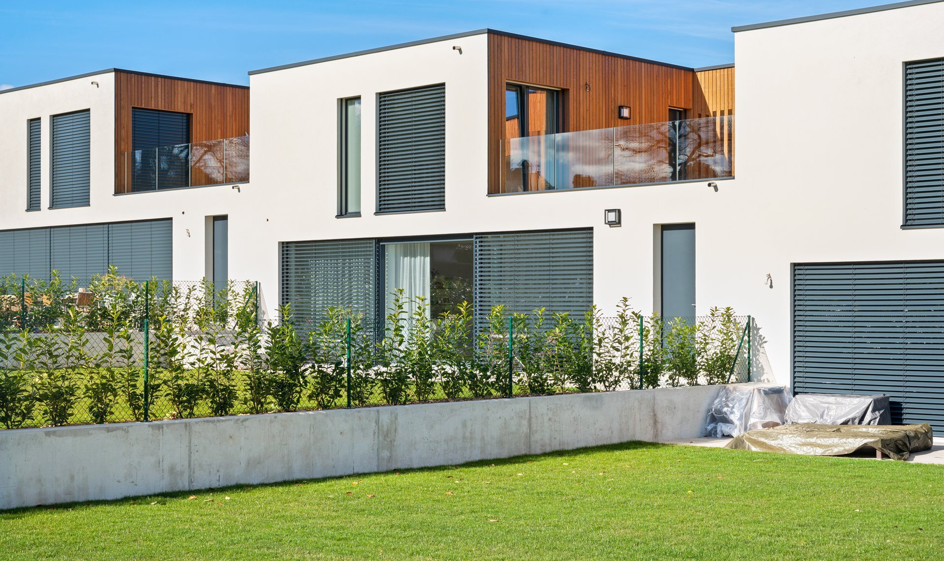 Une rangée de maisons modernes avec une grande pelouse devant elles.