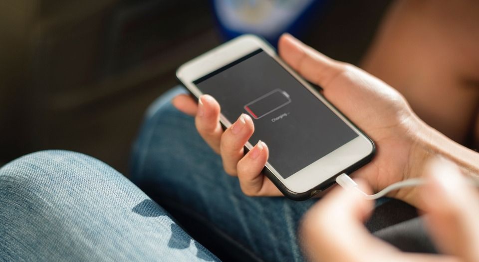 A Person Holding a Phone with A Low Battery Indicator — DevicePro - Phone & Tablet Specialist In Cannonvale, QLD 