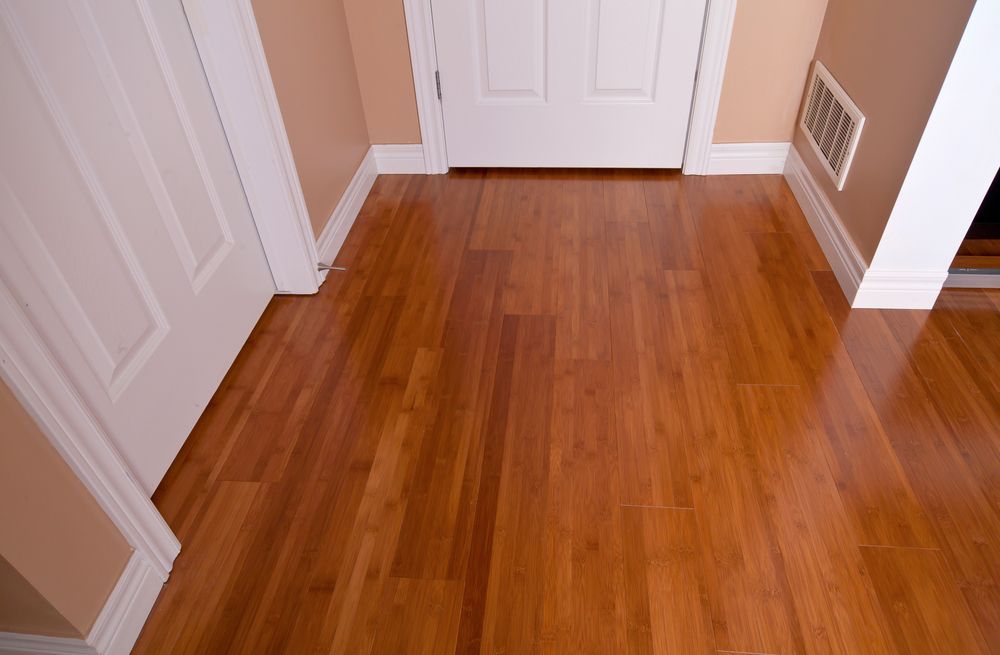 A hallway with hardwood floors and white doors.