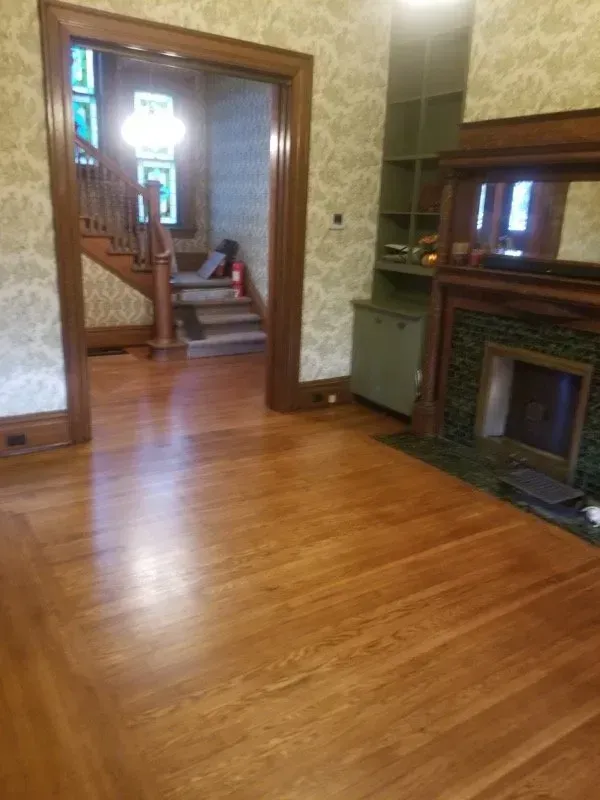 A living room with hardwood floors and a fireplace.