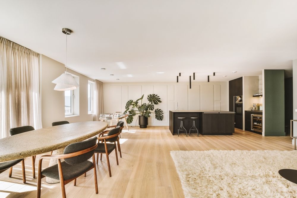 A kitchen with white cabinets , granite counter tops , stainless steel appliances and a large island.