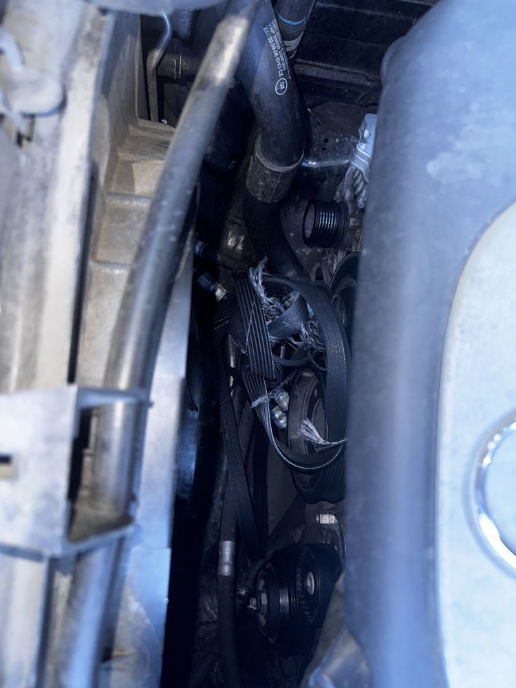A close up of a car engine with a hose coming out of it.