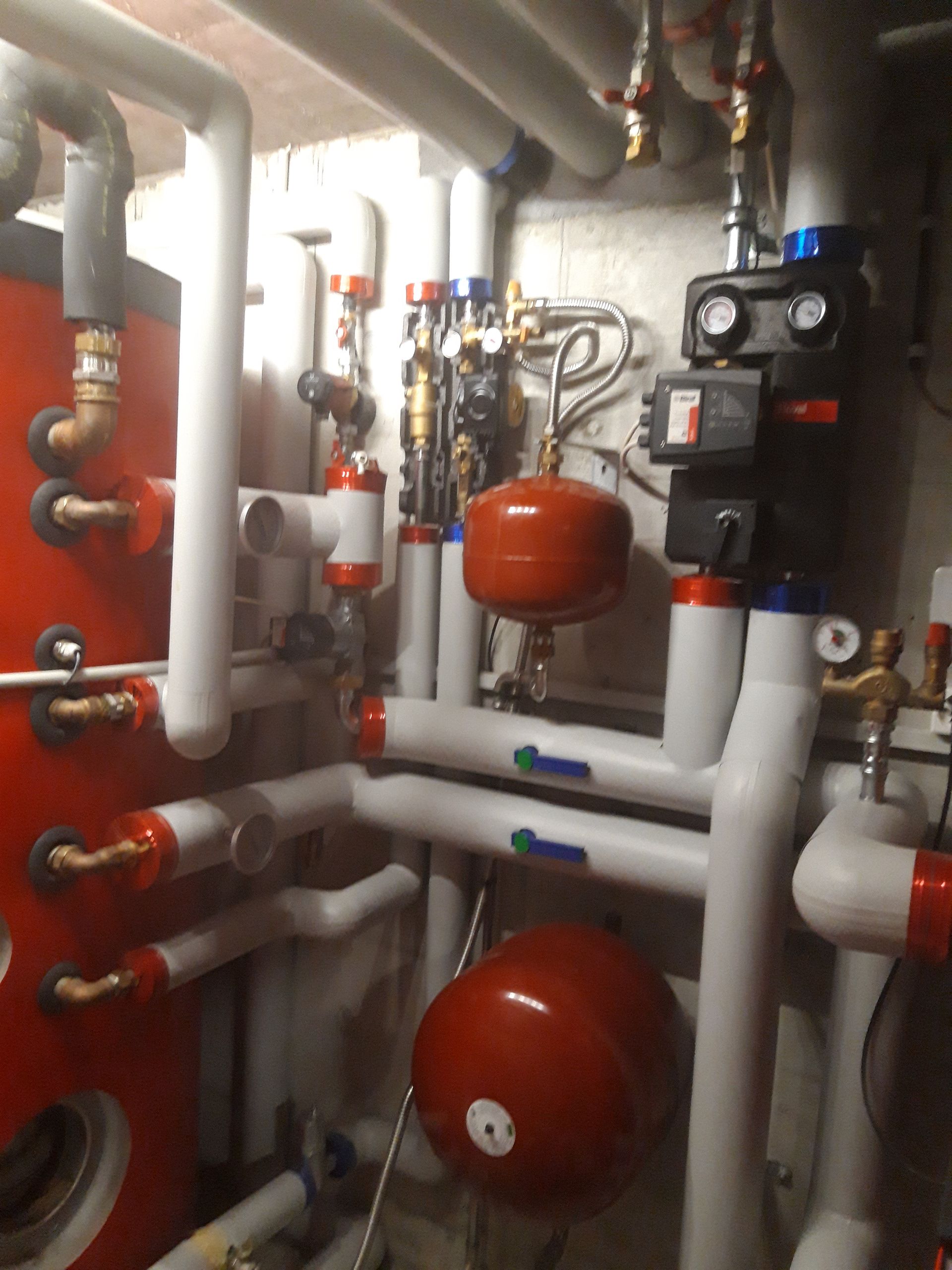 Une pièce remplie de nombreux tuyaux et vannes