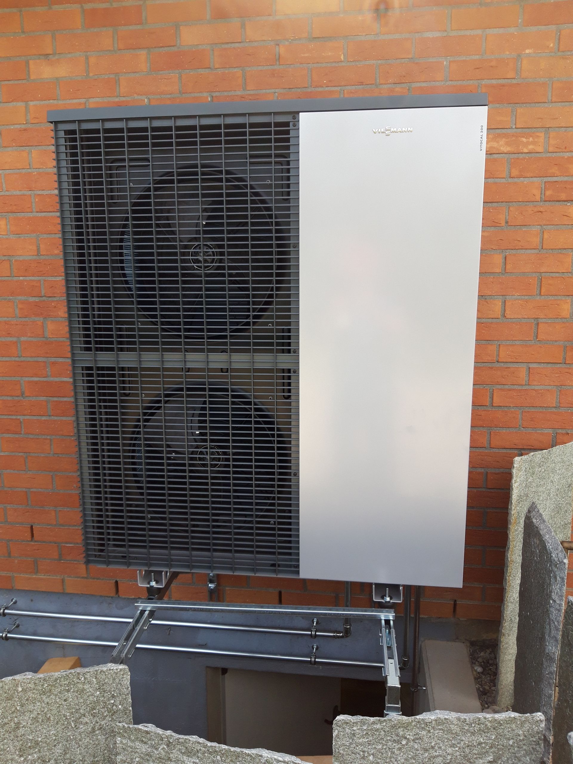Un grand climatiseur est monté sur un mur de briques