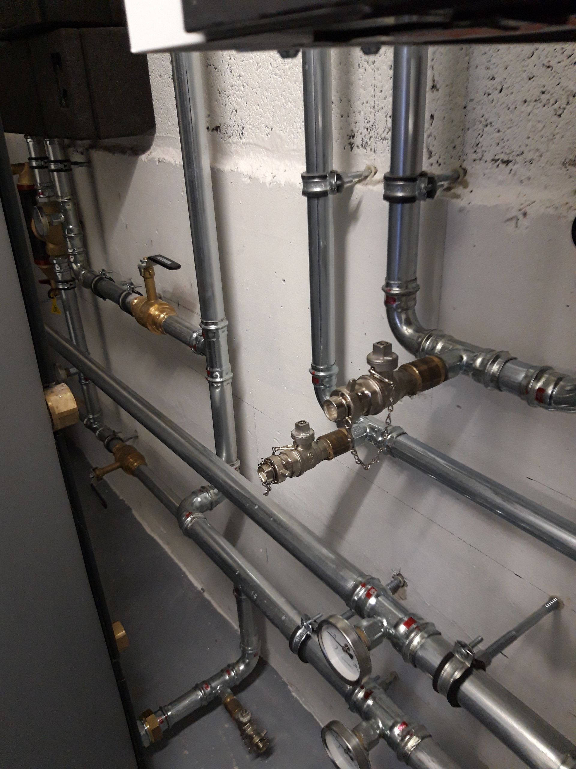 Une pièce remplie de nombreux tuyaux et vannes