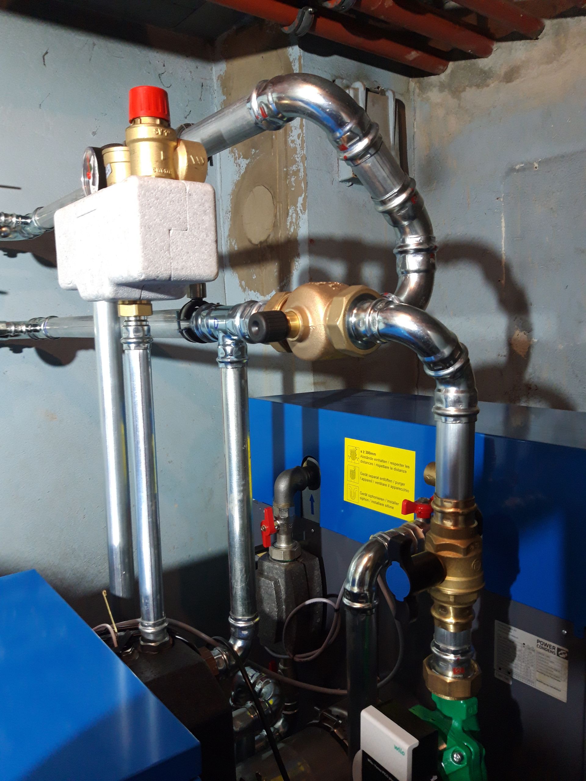 Une chaudière bleue avec un panneau jaune dessus