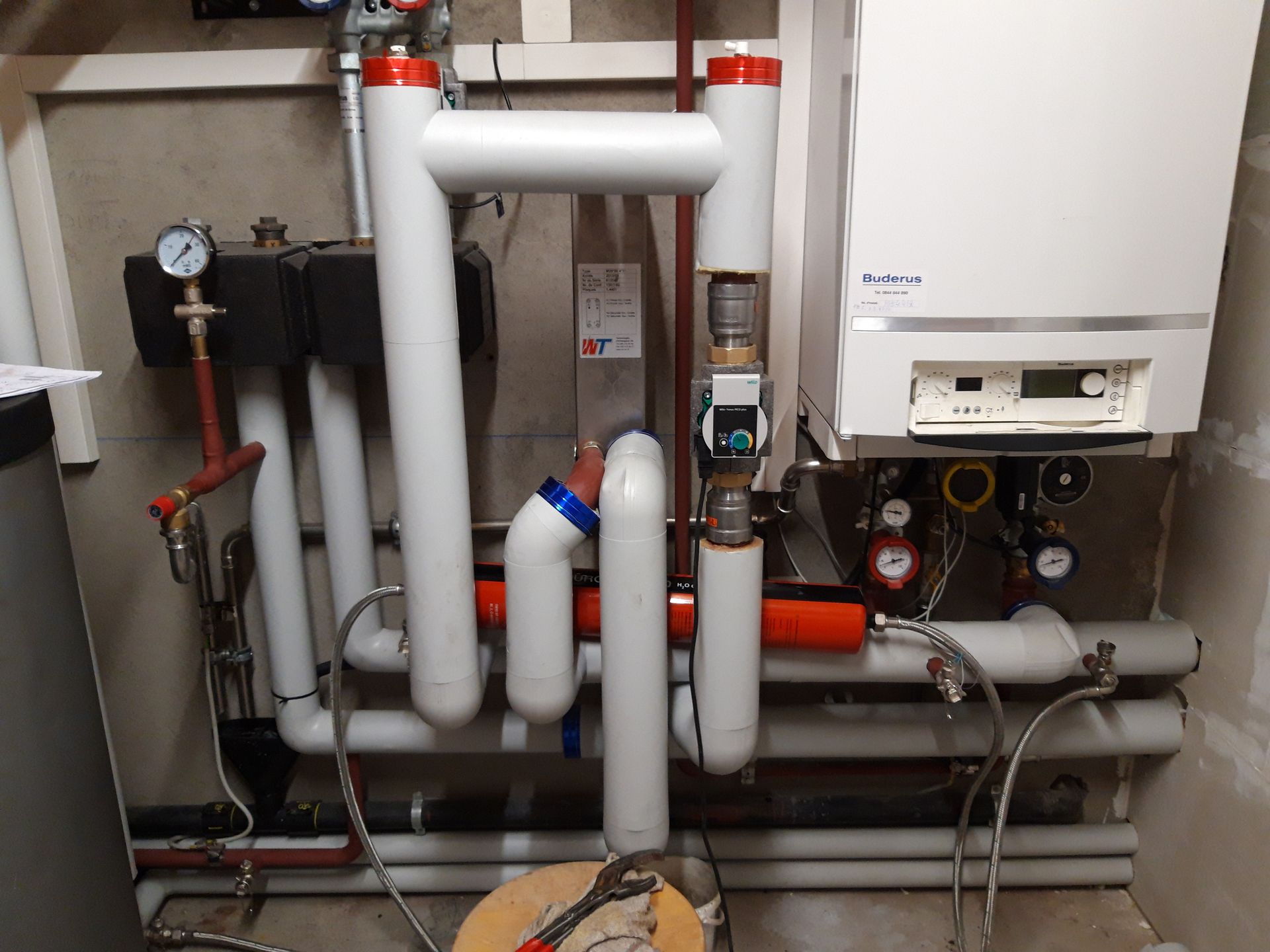 Une pièce avec beaucoup de tuyaux et une chaudière