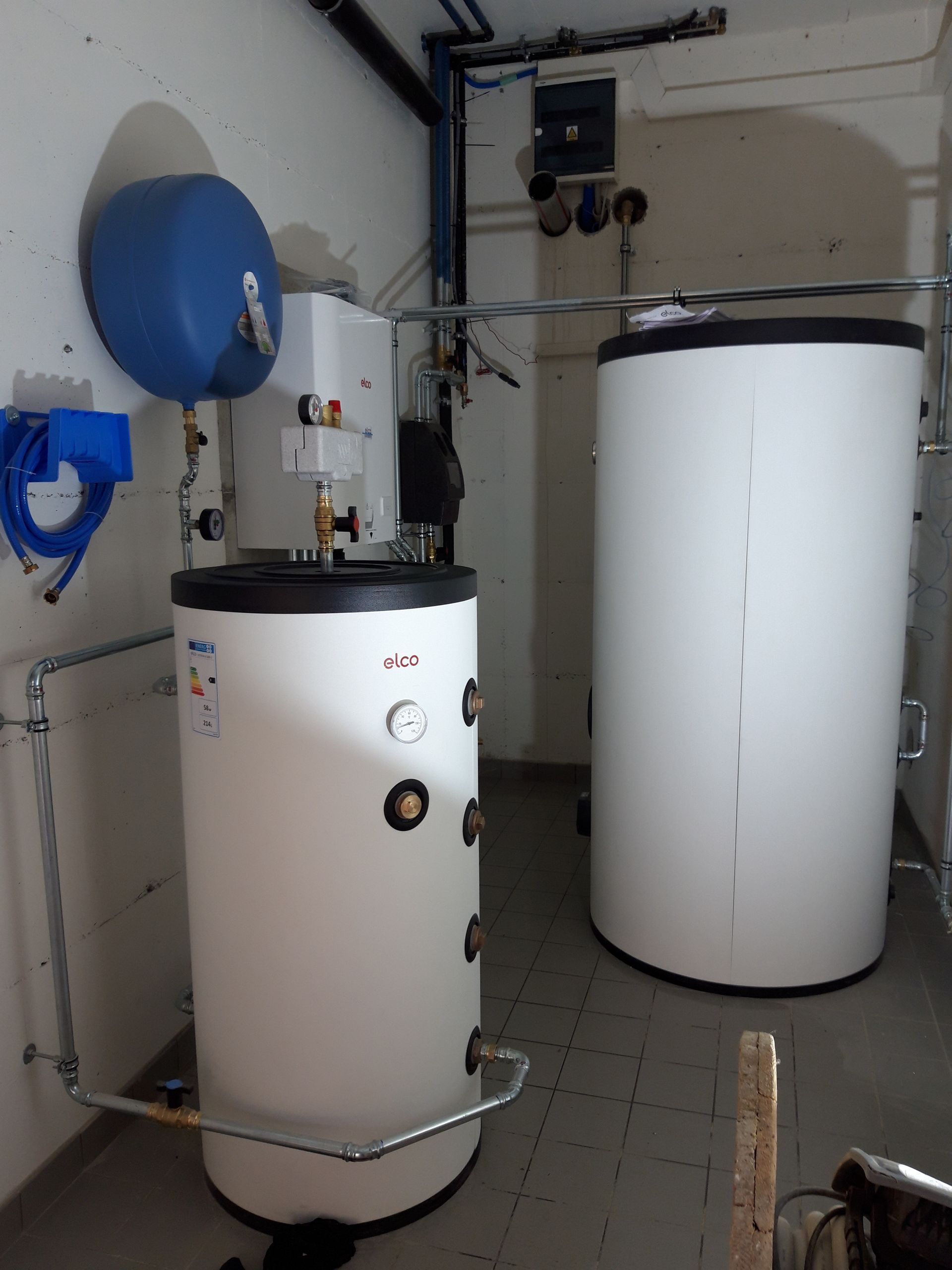 Une pièce avec deux cylindres blancs et un réservoir bleu