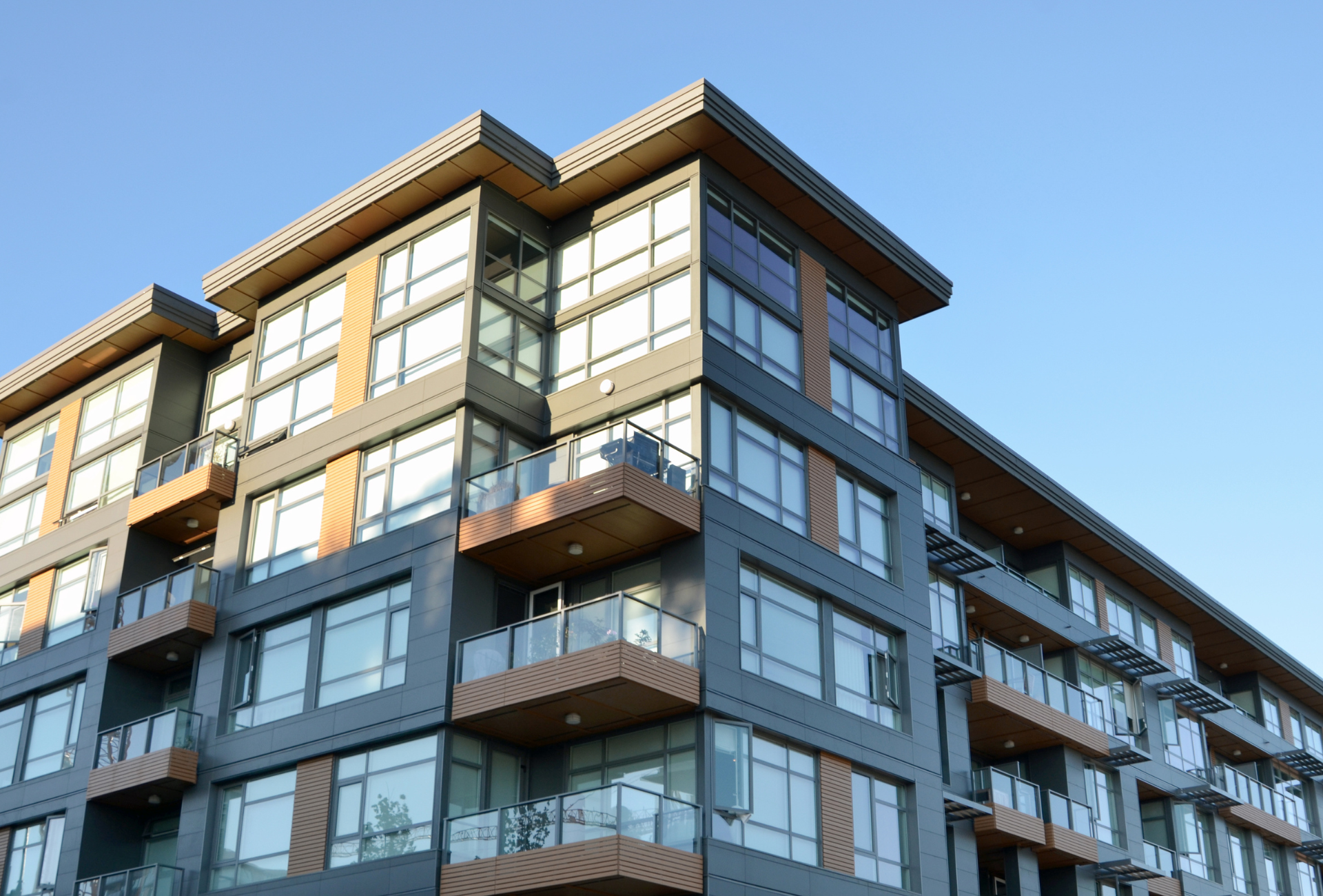 A long hallway in a modern office building with lots of windows.