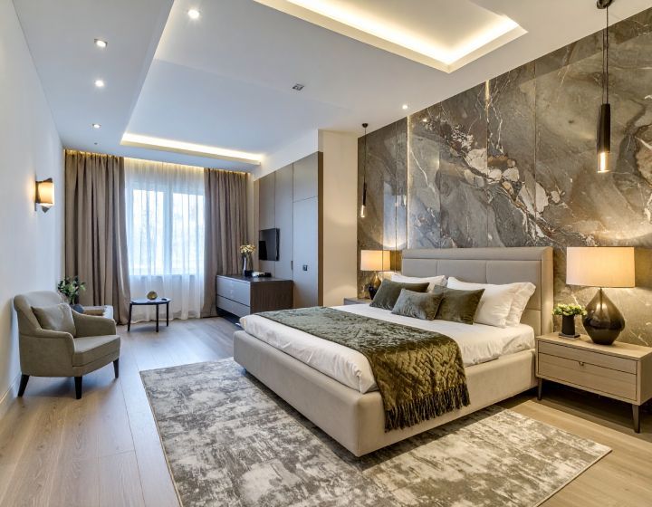 Luxurious bedroom with marble accent wall, platform bed, neutral tones, and ambient lighting.
