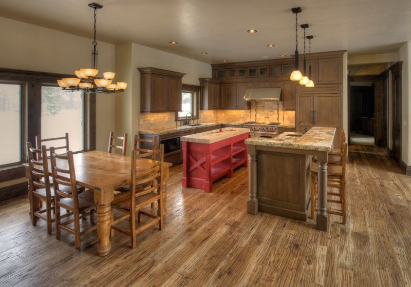 A kitchen with a table and chairs and a red island.