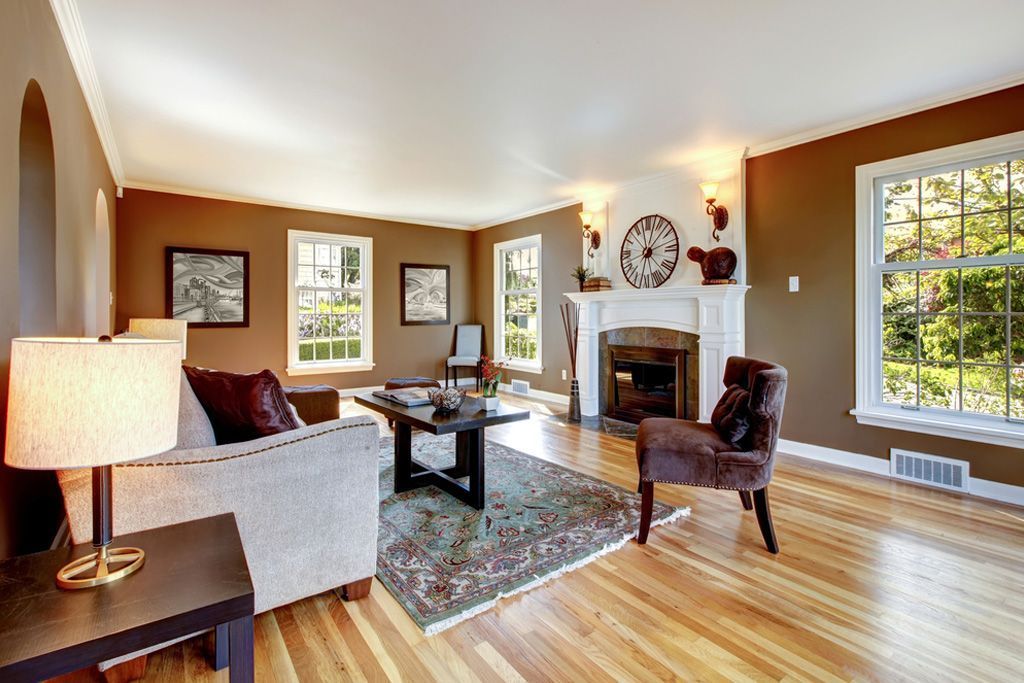 A living room with hardwood floors and brown walls