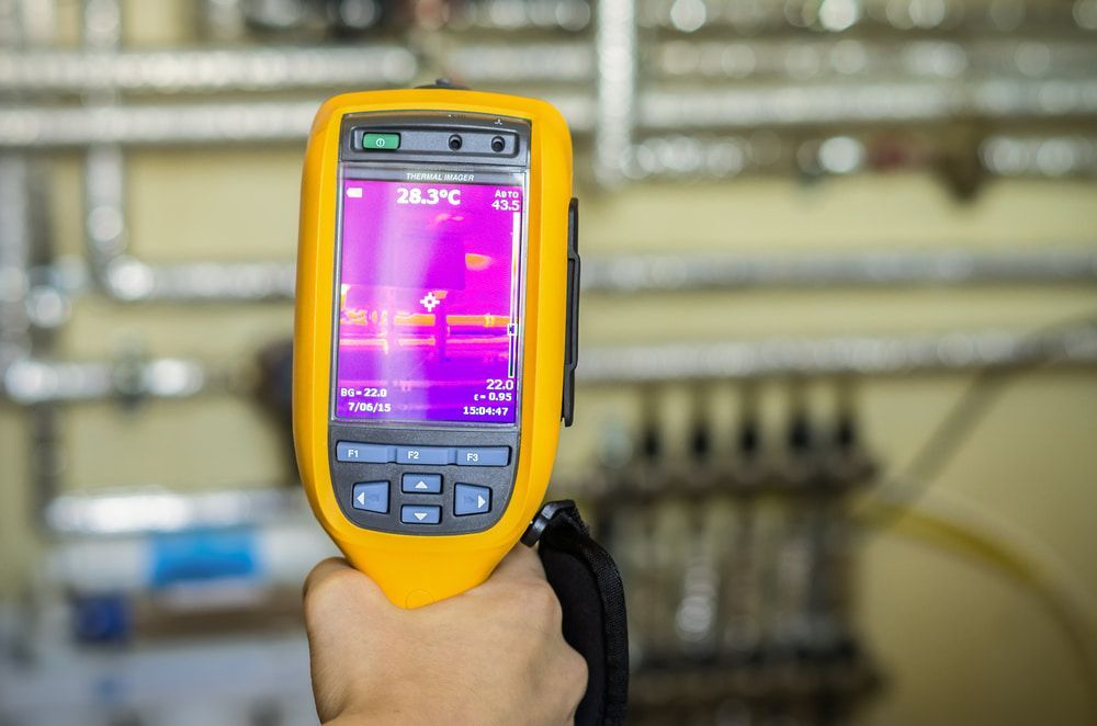 A Person Is Holding A Thermal Camera In Their Hand — Blueline Plumbing Services in Loganlea, QLD