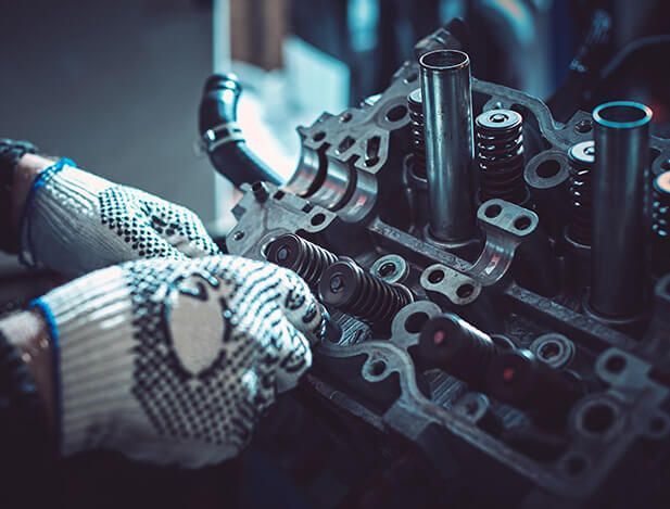 A person wearing gloves is working on a car engine.