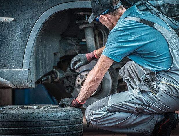 A man is working on a car in a garage.
