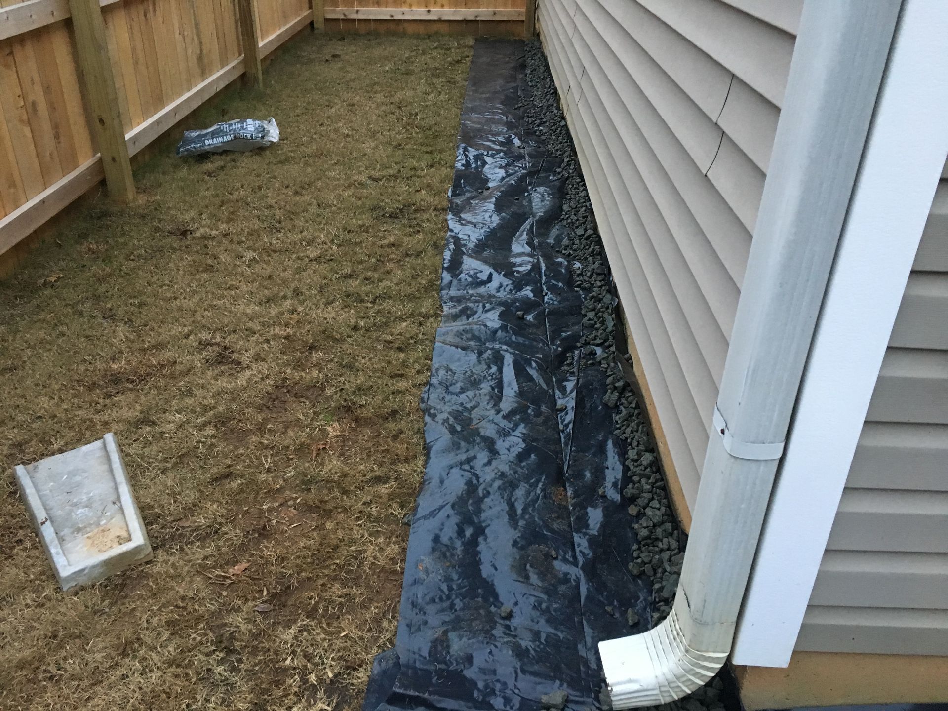 A black tarp is covering the side of a house.
