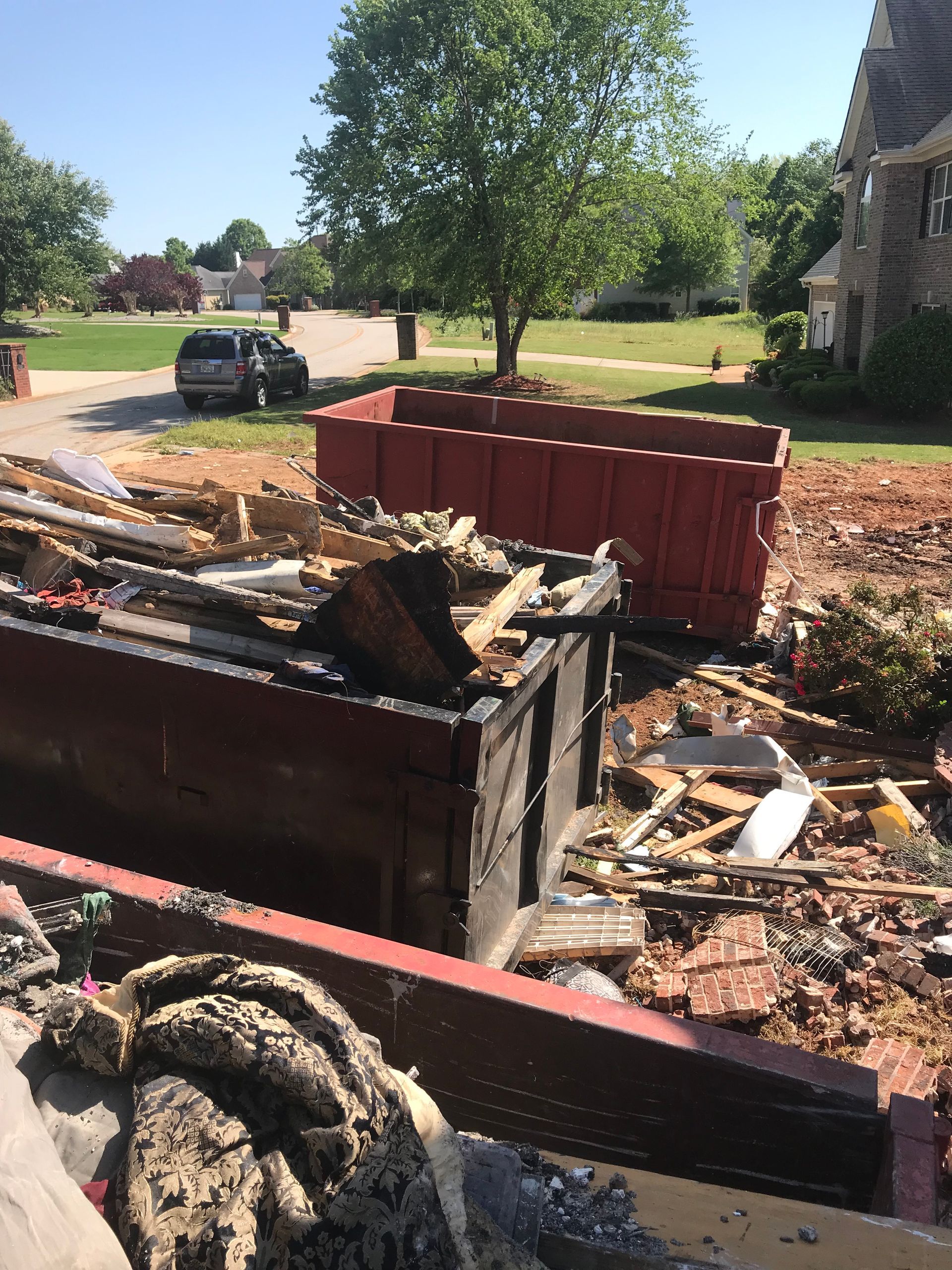 A dumpster filled with a lot of rubble in front of a house