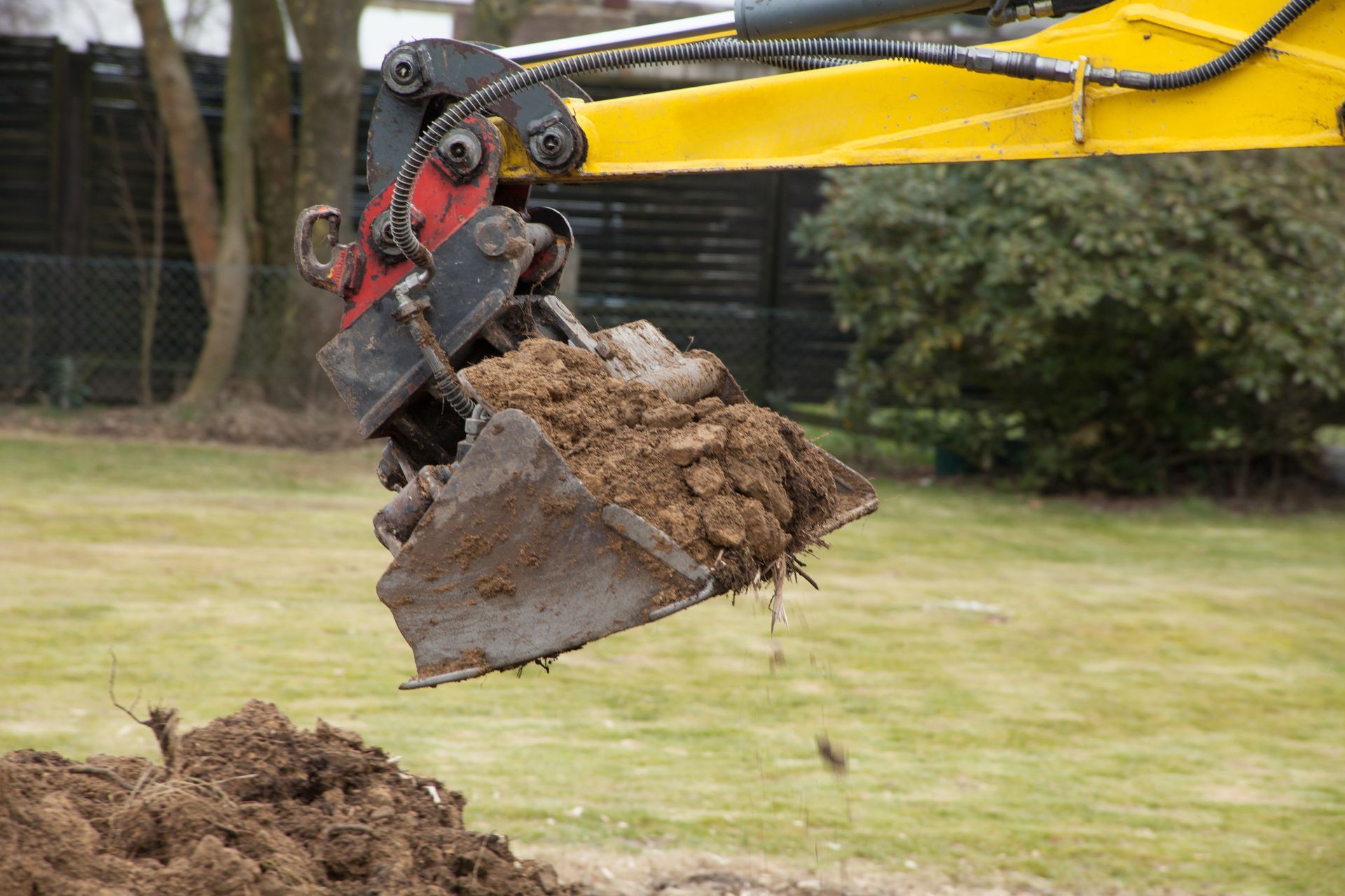 A yellow excavator is digging a hole in the ground.