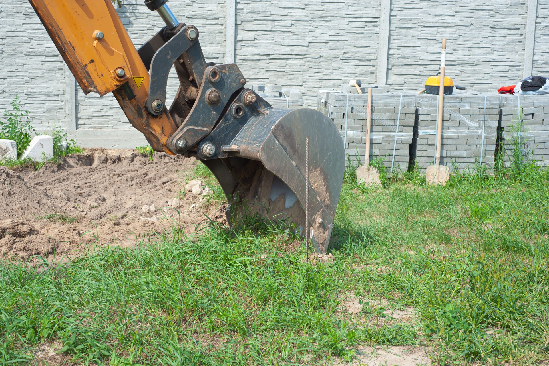 A bulldozer is digging a hole in the grass.