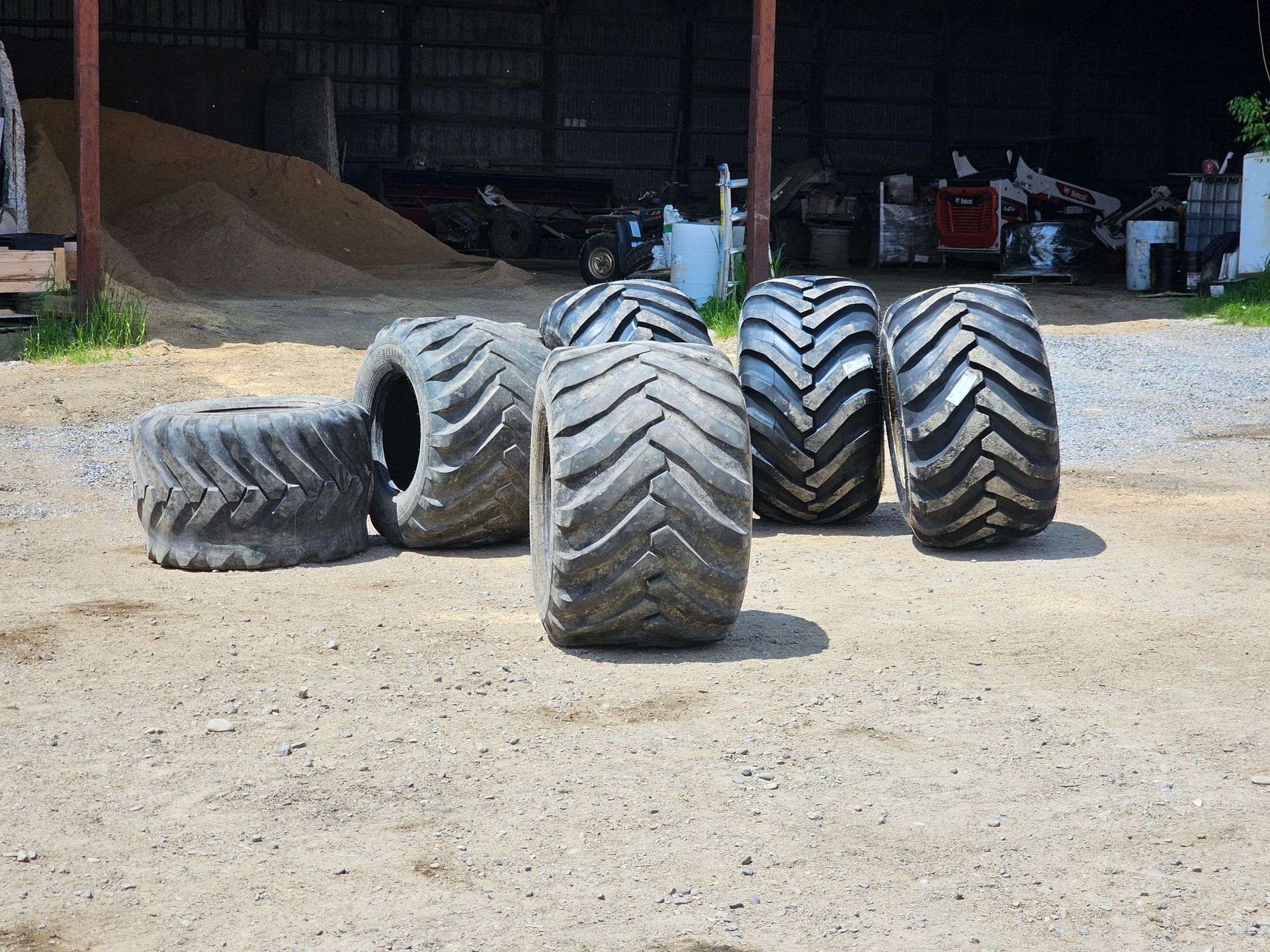 A bunch of tires are sitting on the ground in front of a building.