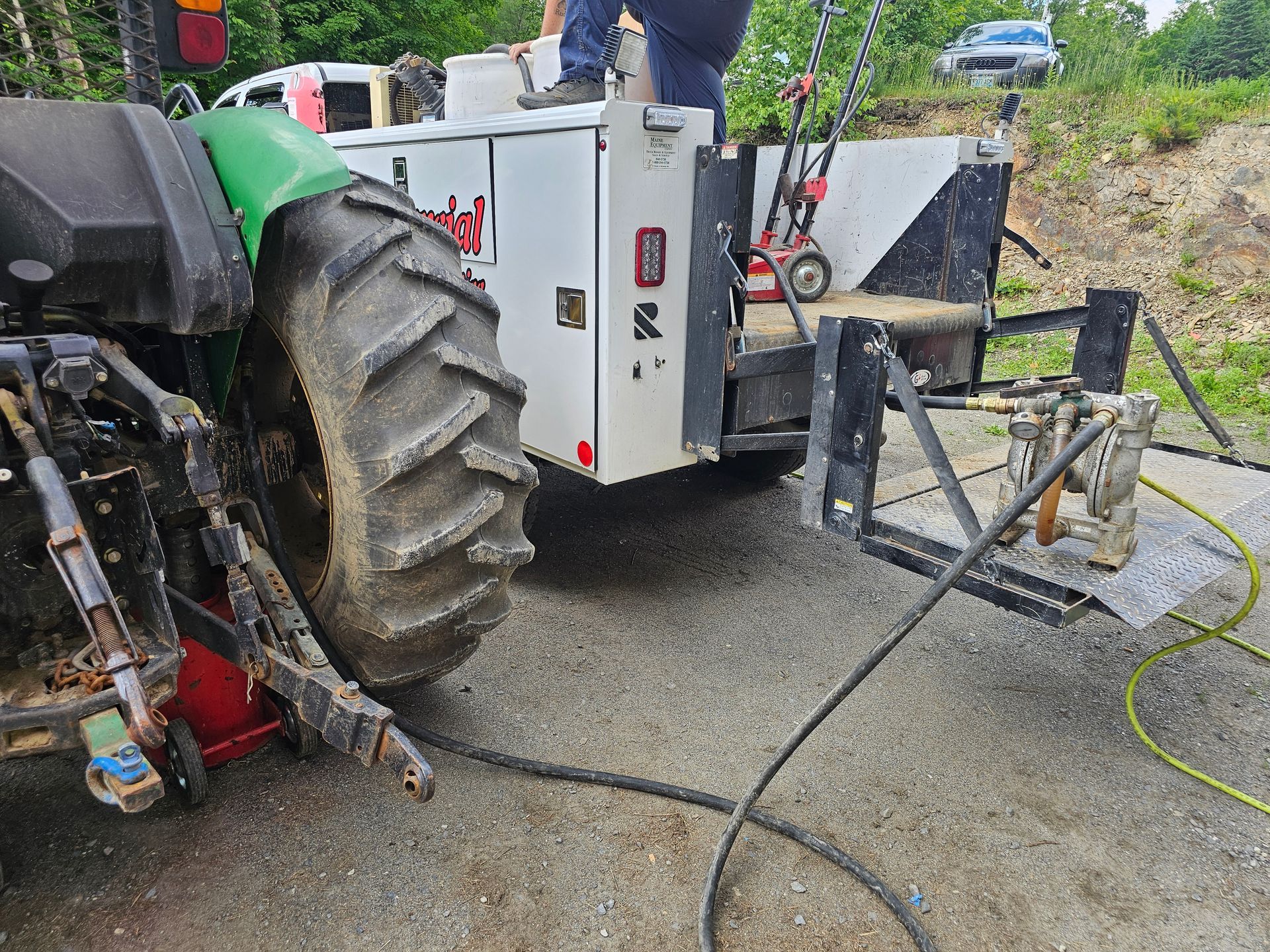 A tractor is parked on the side of the road next to a trailer.