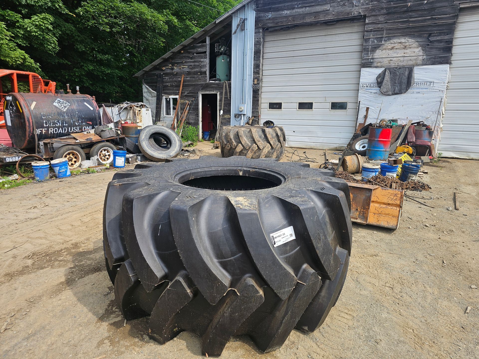 A large tire is sitting in front of a garage door