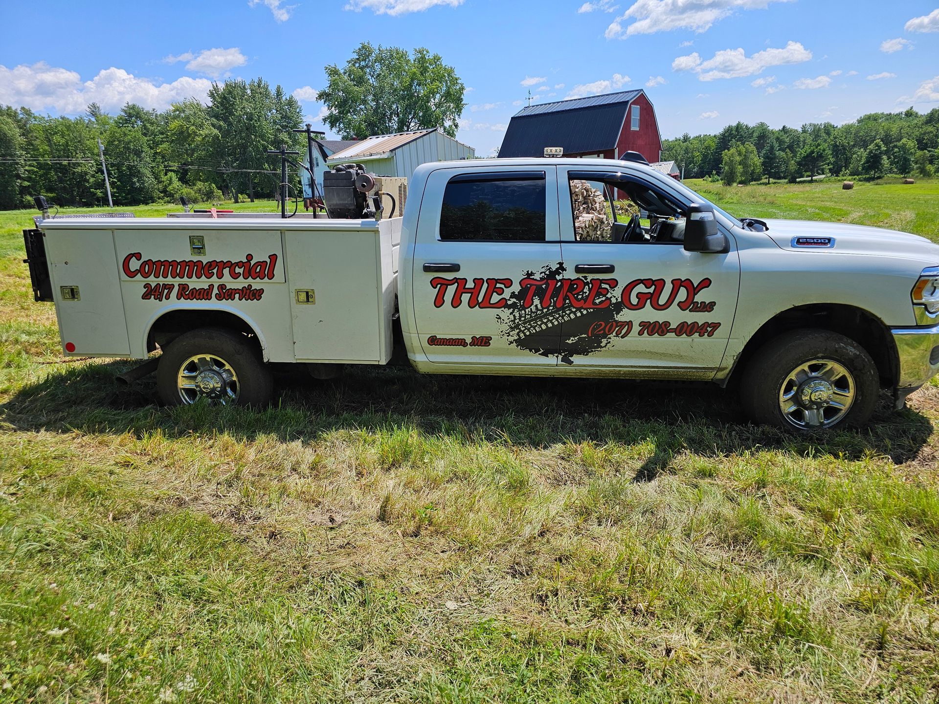 A white truck is parked in a grassy field.