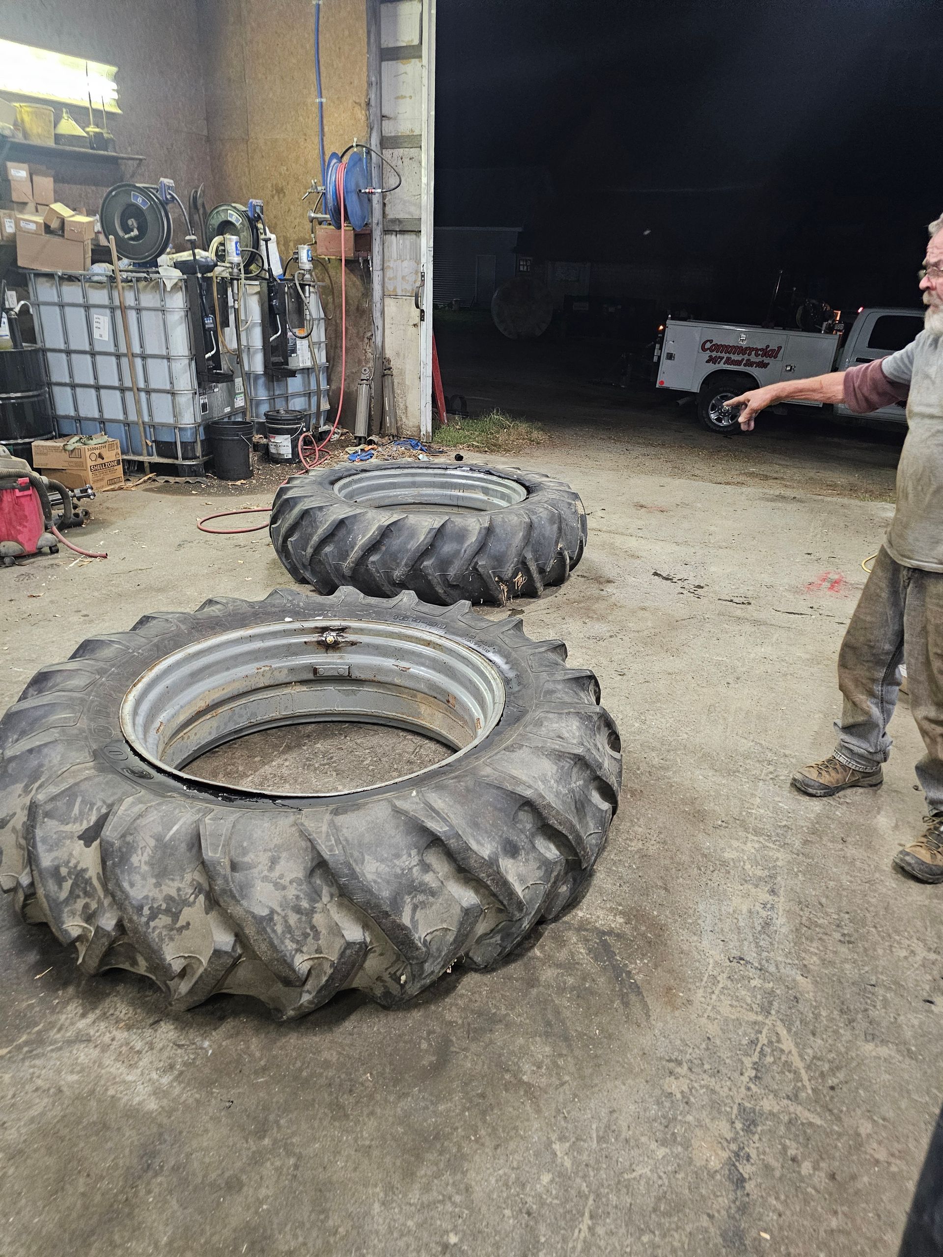 A man is standing next to a tire in a garage.