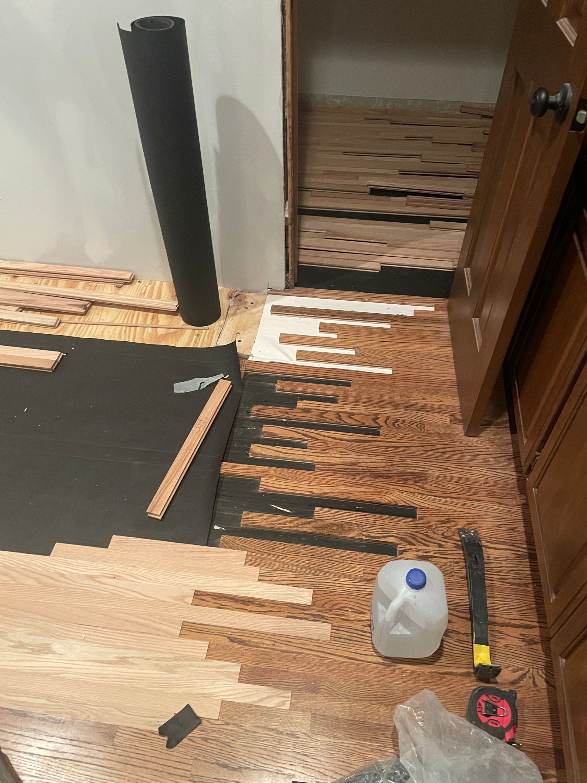 An entrance to a room with hardwood floors being installed.