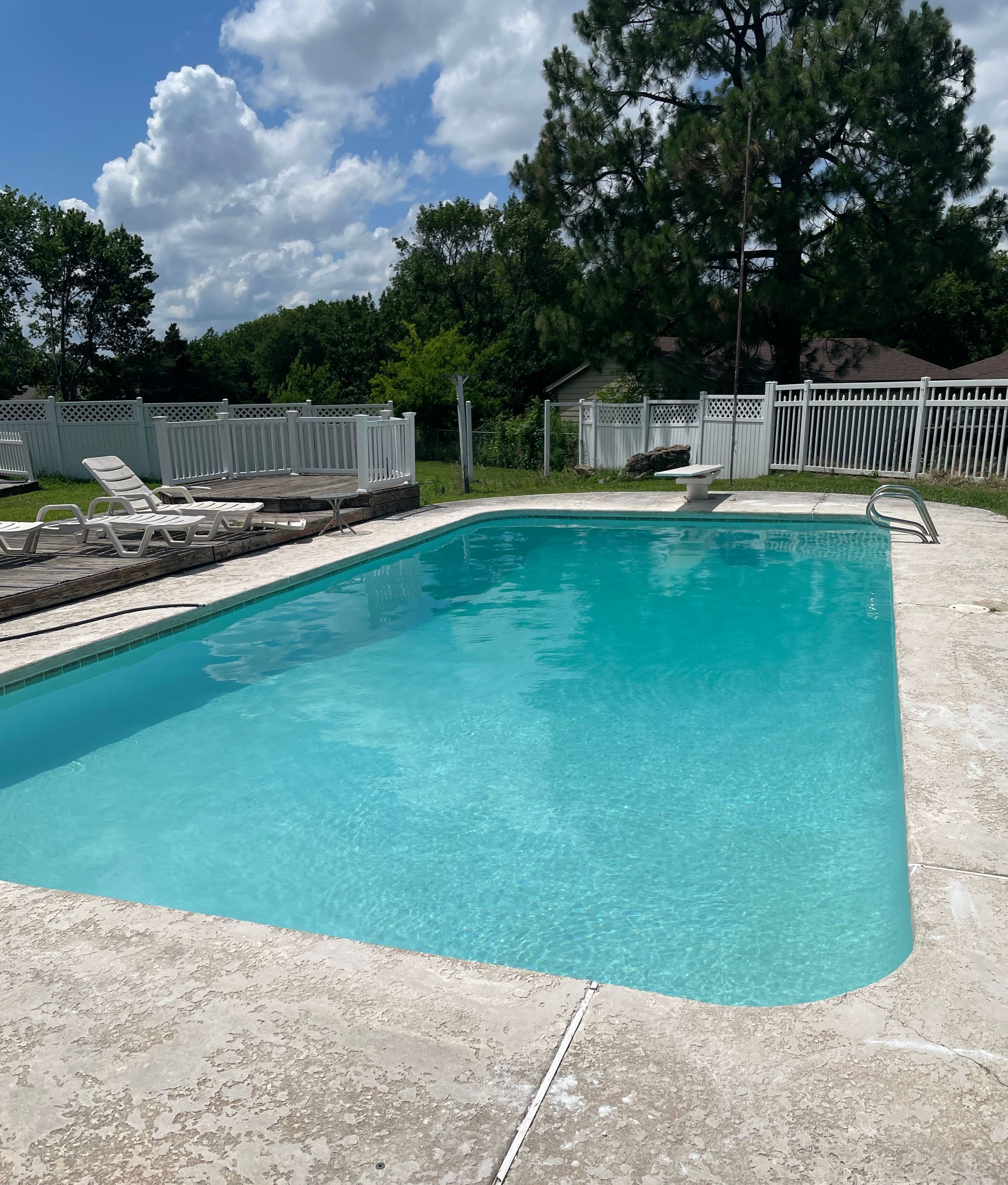 A large swimming pool with a white fence around it