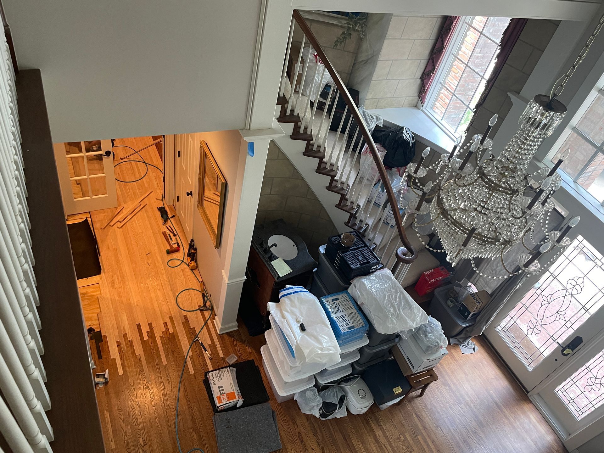 An aerial view of a living room with stairs and a chandelier.