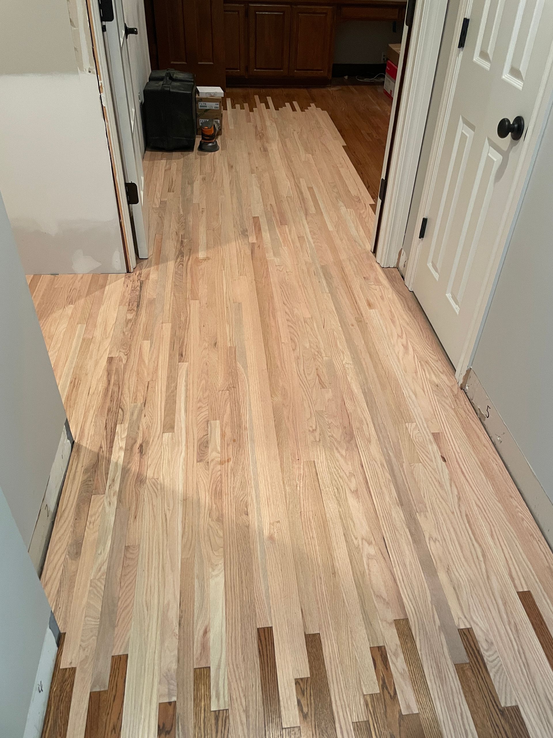 A hallway with hardwood floors in a house.