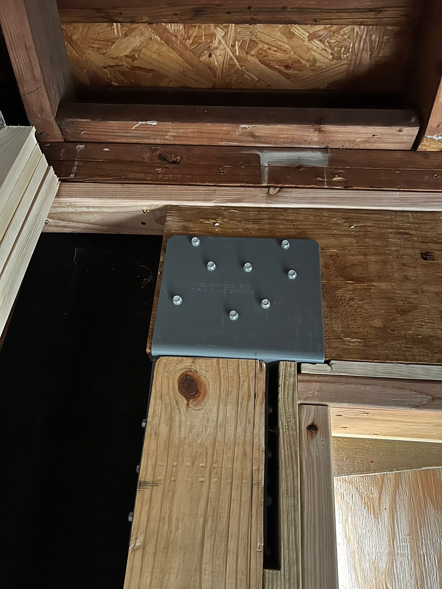 Drywall is removed from a garage wall and a supporting column is visible.