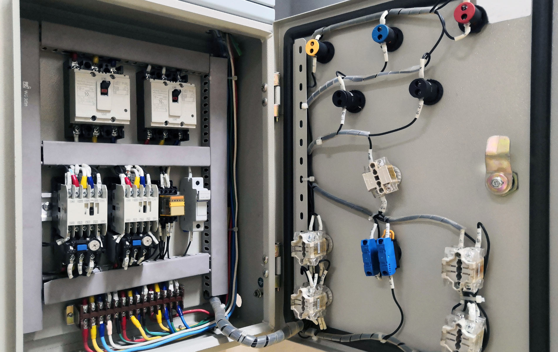 The inside of a electrical box with a lot of wires coming out of it.