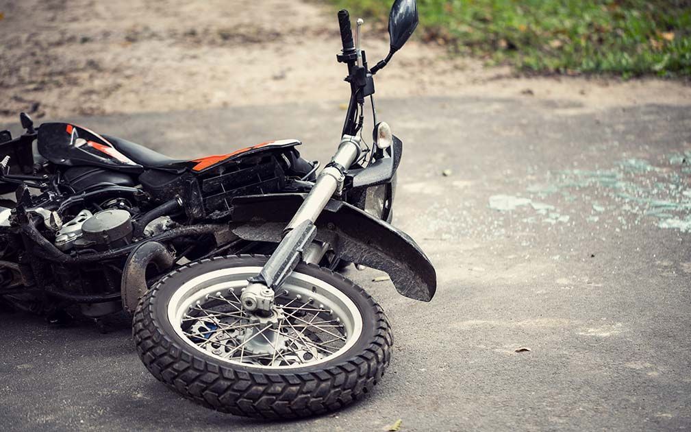 A motorcycle has crashed on the side of the road.